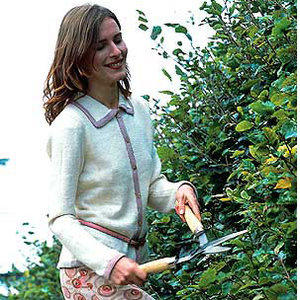 Model wearing contrast trim knitted jacket and doing gardening