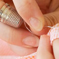 close-up of sewing with thimble - Make do and mend: simple sewing repairs - Craft - allaboutyou.com