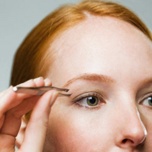 woman shaping her eyebrows