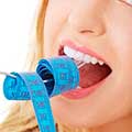 Woman eating tape measure - Quiz: what's the right diet for you? - diet plan - diet & wellbeing - allaboutyou.com