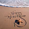 Happy New Year written in sand - New Year, new you: your healthy guide to 2015 - New Year resolutions - diet & wellbeing - allaboutyou.com