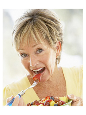 Older woman eating fruit salad