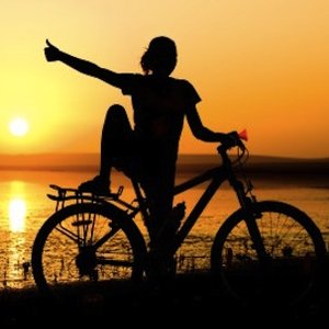 cycling woman giving thumbs-up against sunset - Pedal into a summer of cycling: the UK's best cycle routes - Days out - allaboutyou.com