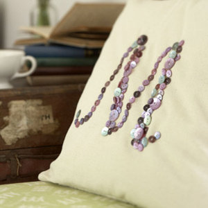 Cream cushion with the letter M sewn in buttons by Sophie Conran